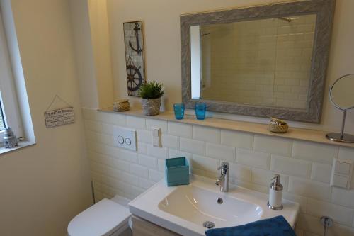 a bathroom with a sink and a mirror and a toilet at Meer-Zeit - EG- Treibgut in Kappeln