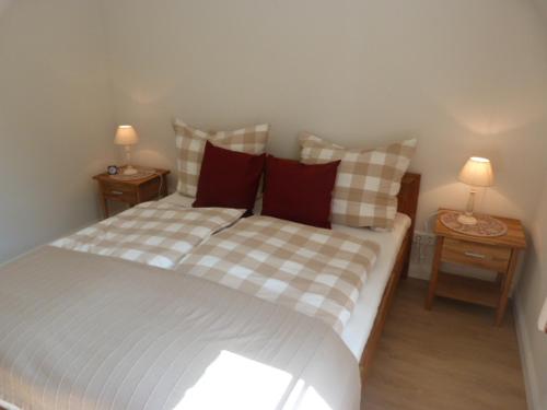 Un dormitorio con una cama con dos mesitas de noche y dos lámparas. en Lasse -EG -Rollstuhlgerecht, en Kappeln