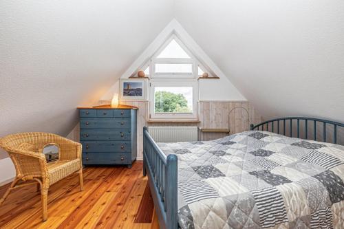 a bedroom with a bed and a dresser and a window at Oberdeck in Maasholm