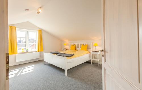 a white bedroom with a bed and a window at Ole Maisonette - OG links in Kappeln