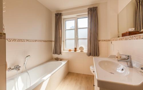 a white bathroom with a tub and a sink at Ole Maisonette - OG links in Kappeln