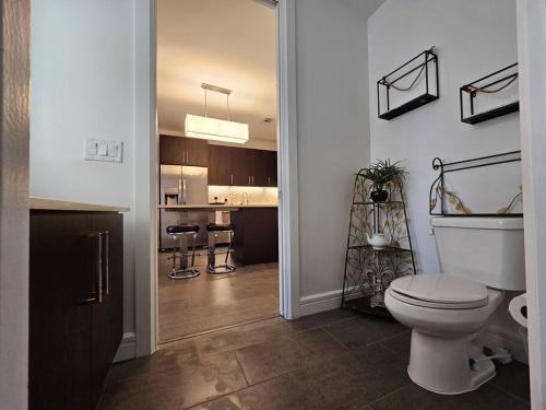 a bathroom with a toilet and a kitchen with a counter at Luxury Highrise in Midtown - Skyline Views and Chic Decor in Houston
