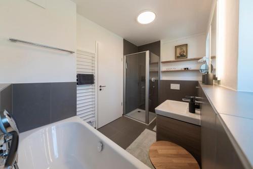 a bathroom with a white tub and a sink at Seemanns Heimat - A6 in Kappeln