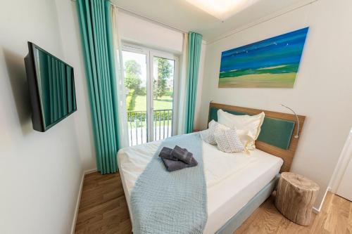 a small bedroom with a bed with a window at Seemanns Heimat - A6 in Kappeln