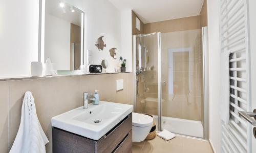 een witte badkamer met een wastafel en een douche bij Küstennebel - D2 in Kappeln