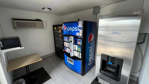 a large blue refrigerator in a room with a tv at Motel 6-Sacramento, CA - North in Sacramento