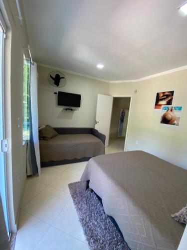 1 dormitorio con 1 cama y TV de pantalla plana en Linda casa em Tarituba, en Paraty