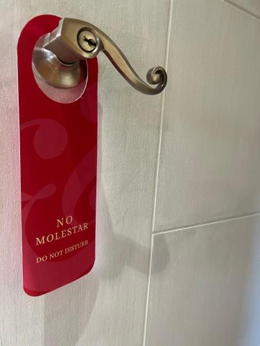 a red tag on the door of a bathroom at Hotel Boutique Casa&Alma in Puerto Varas
