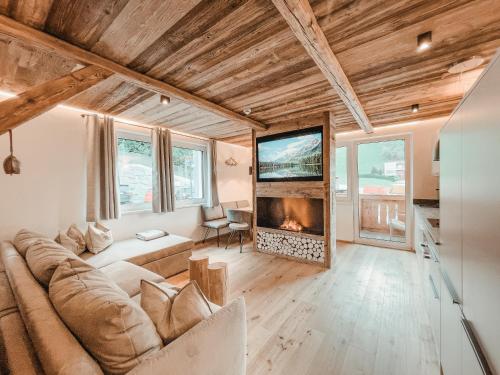 a living room with a couch and a fireplace at AlpenLuxus' OLDWOOD CHALET with balcony & car park in Fügen