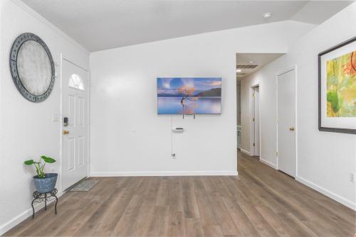 an empty hallway with white walls and wood floors at 3BR Cozy Home~ Stylish & New ~ UC Merced ~ en route Yosemite! in Merced