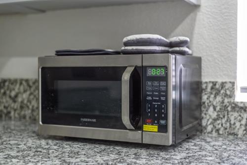 a microwave sitting on a counter with two towels on top at 3BR Cozy Home~ Stylish & New ~ UC Merced ~ en route Yosemite! in Merced