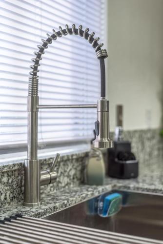 a kitchen sink with a faucet on a counter at 3BR Cozy Home~ Stylish & New ~ UC Merced ~ en route Yosemite! in Merced