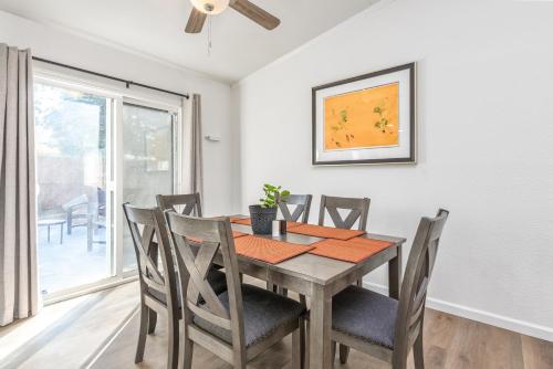 a dining room with a wooden table and chairs at 3BR Cozy Home~ Stylish & New ~ UC Merced ~ en route Yosemite! in Merced