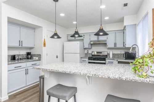 a kitchen with white cabinets and a counter top at 3BR Cozy Home~ Stylish & New ~ UC Merced ~ en route Yosemite! in Merced