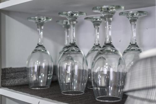a row of wine glasses sitting on a shelf at 3BR Cozy Home~ Stylish & New ~ UC Merced ~ en route Yosemite! in Merced