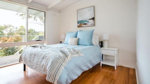 um quarto com uma cama e uma janela em The Grove em Flinders