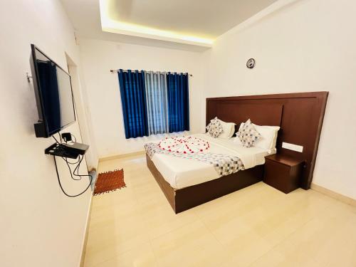 a bedroom with a bed and a flat screen tv at Spring Valley in Anachal