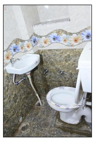 a bathroom with a toilet and a sink at Bhanwar Villa Guest House in Pāl