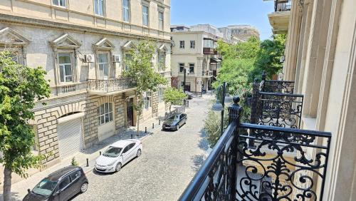een balkon met uitzicht op een straat met geparkeerde auto's bij Du Port Boutique Hotel in Baku