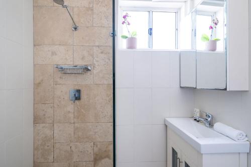 a bathroom with a shower and a sink at Vibrant Beachside Retreat - 2BR Unit in Freshwater in Freshwater