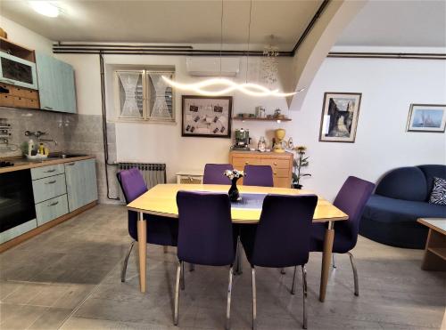 a kitchen and dining room with a table and purple chairs at Apartment LEMONA in Makarska