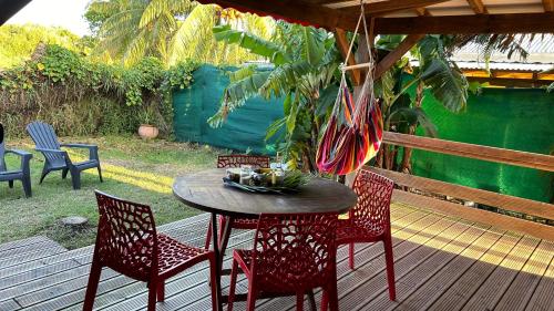une table et des chaises en bois sur une terrasse en bois dans l'établissement La kaz à sucre : bungalow au calme proche de tout., à Saint-François