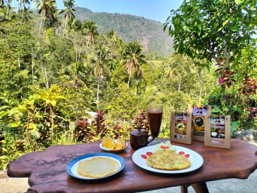 a wooden table with food and a glass of beer at Ananda Homestay Lemukih in Singaraja