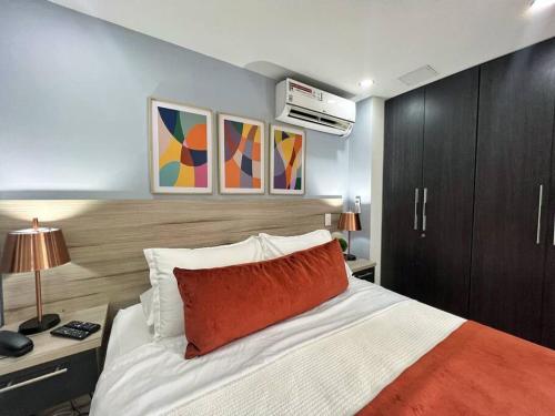een slaapkamer met een bed met een rood kussen erop bij Aparta Loft La Frontera Poblado in Medellín
