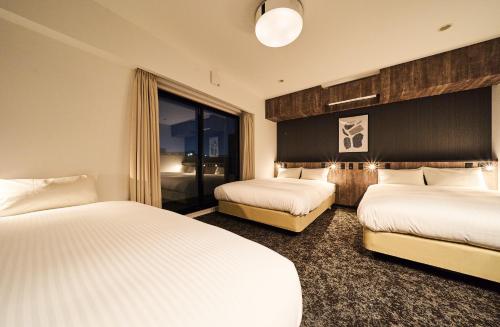 福岡的住宿－Grand STAY 博多駅北，酒店客房设有两张床和窗户。