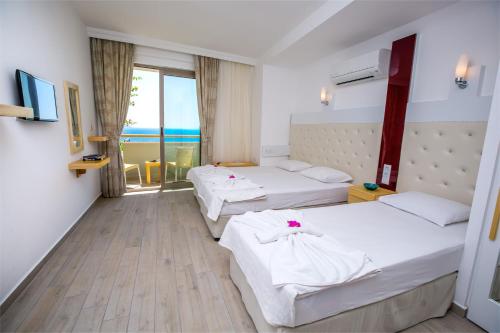 a hotel room with two beds and a balcony at Defne Hotel in Kas