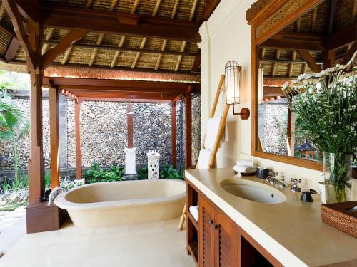 La salle de bains est pourvue d'une baignoire, d'un lavabo et d'un miroir. dans l'établissement Villa Maridadi by Elite Havens, à Canggu