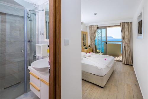 a bathroom with a tub and a sink and a shower at Defne Hotel in Kaş