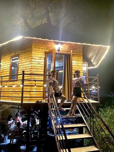 two women standing on the stairs of a tree house at Nhà trên cây in Hanoi