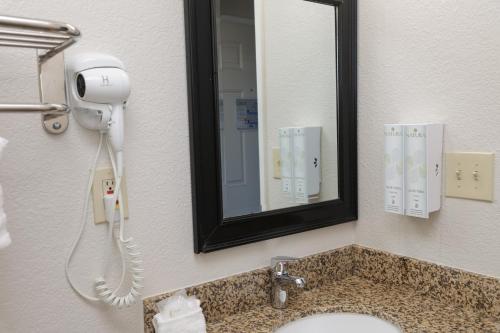 a bathroom with a sink and a mirror and a phone at Sea Breeze Inn - San Simeon in San Simeon