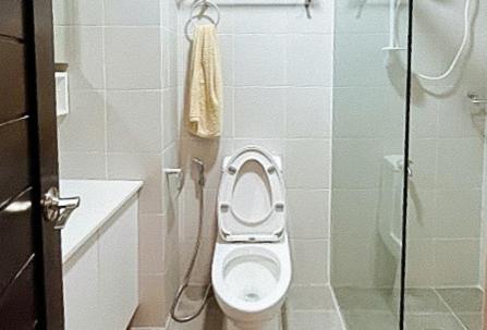 a small bathroom with a toilet and a shower at RedDoorz @ Leoncia Apartelle Mandaue City in Mandaue City