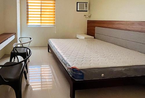 a bedroom with a bed and a chair in it at RedDoorz @ Leoncia Apartelle Mandaue City in Mandaue City