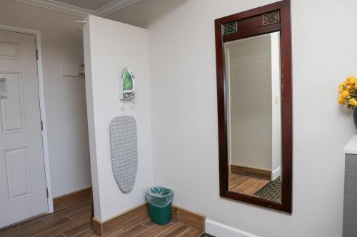 a mirror on a wall next to a bathroom at Sea Breeze Inn - San Simeon in San Simeon