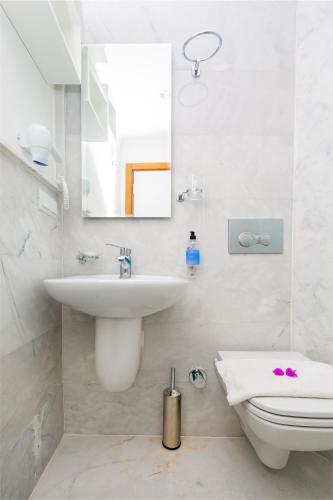 a bathroom with a sink and a toilet and a mirror at Defne Hotel in Kas