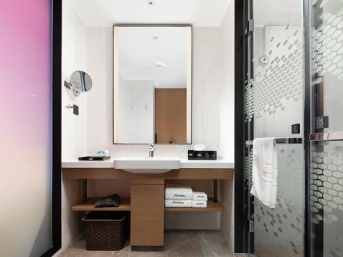een badkamer met een wastafel en een spiegel bij Hampton by Hilton Shenzhen Baoan Stadium in Shenzhen