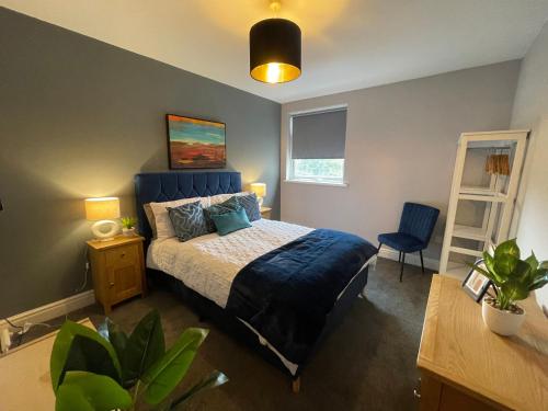 a bedroom with a bed with a blue bedspread at 5- Large 1 bed Apartment- West Midlands 
