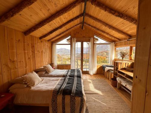 a bedroom with two beds in a room with windows at Alto Castillo in Villa Cerro Castillo