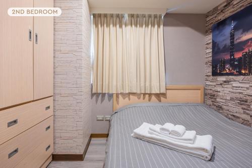 um quarto com uma cama com duas toalhas em Comfy & Central 2B1b, Sleeps 5, 3min to Daan MRT 舒適市中心 2房1衛 睡5人 3分到大安站 em Taipei