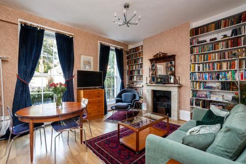 a living room with a couch and a table and a fireplace at Ultra Central London, Modern Flat in Leafy Street in London