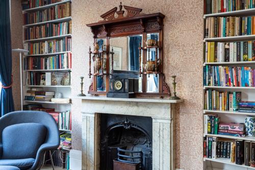 a fireplace with a mirror on top of it at Ultra Central London, Modern Flat in Leafy Street in London