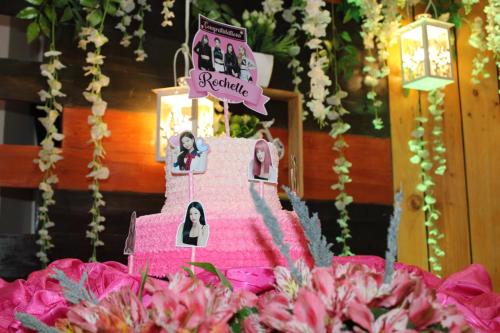 a pink wedding cake with a bride and groom at Rosas Garden Hotel in Manila