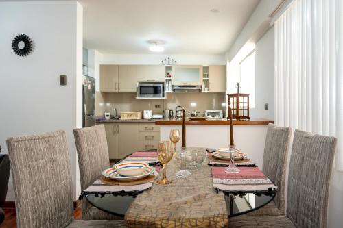 einen Esstisch mit Stühlen und eine Küche in der Unterkunft Aura Apartamento Cusco in Cusco