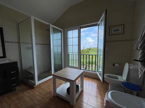 La salle de bains est pourvue d'un lavabo, de toilettes et d'une fenêtre. dans l'établissement Apartamentos em Casa da Avó Inês, à Porto Formoso