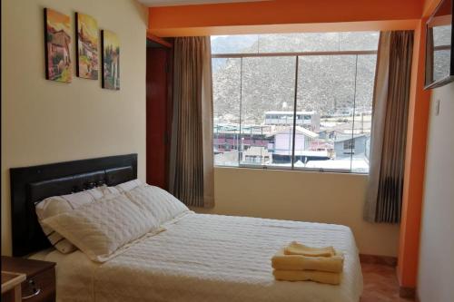 um quarto com uma cama e uma grande janela em ANDINOS DEL COLCA em Chivay
