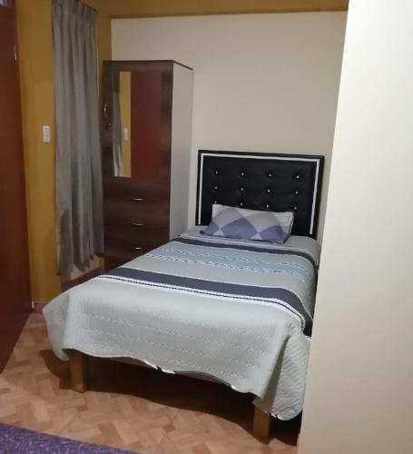 a bedroom with a large bed with blue pillows at ANDINOS DEL COLCA in Chivay