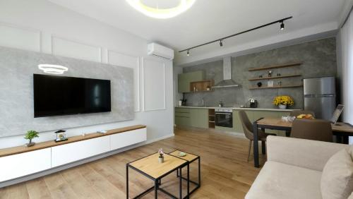 een woonkamer met een flatscreen-tv aan de muur bij 999 Apartments in Tirana